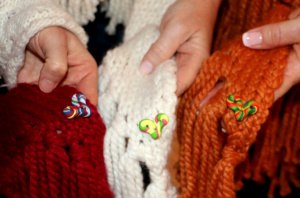 Hands holding Cozmeena shawls and pocket hearts