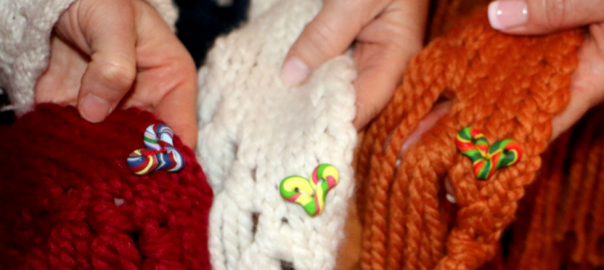 Hands holding Cozmeena shawls and pocket hearts